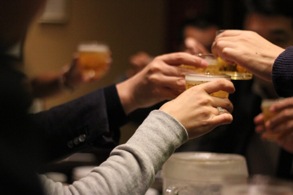 忘年会で乾杯するグラスの様子