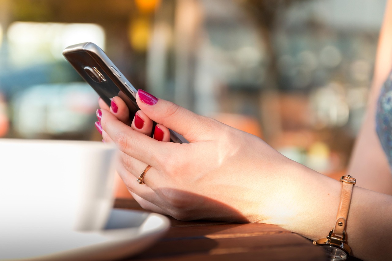スマートフォンでLINEの返信を考える女性